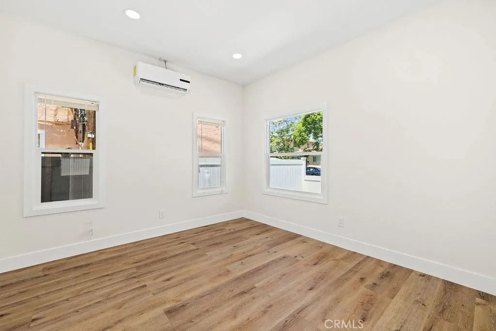 Bright and spacious bedroom featuring recessed lighting, updated flooring, and mini-split system.