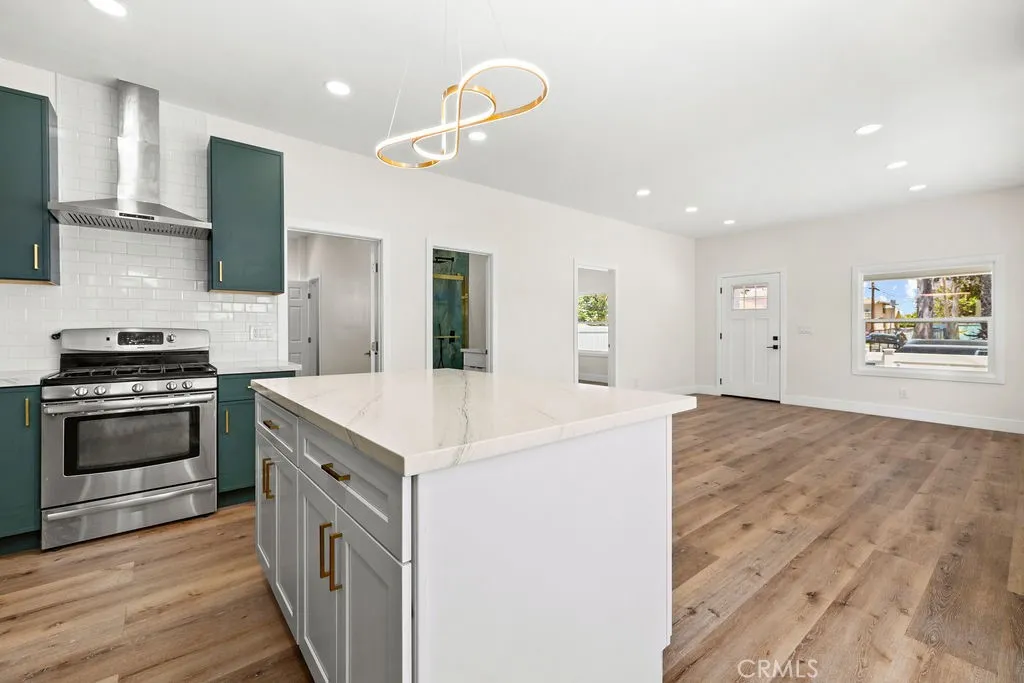 Designer kitchen featuring two-tone slim shaker cabinetry, quartz counters, and modern gold hardware.