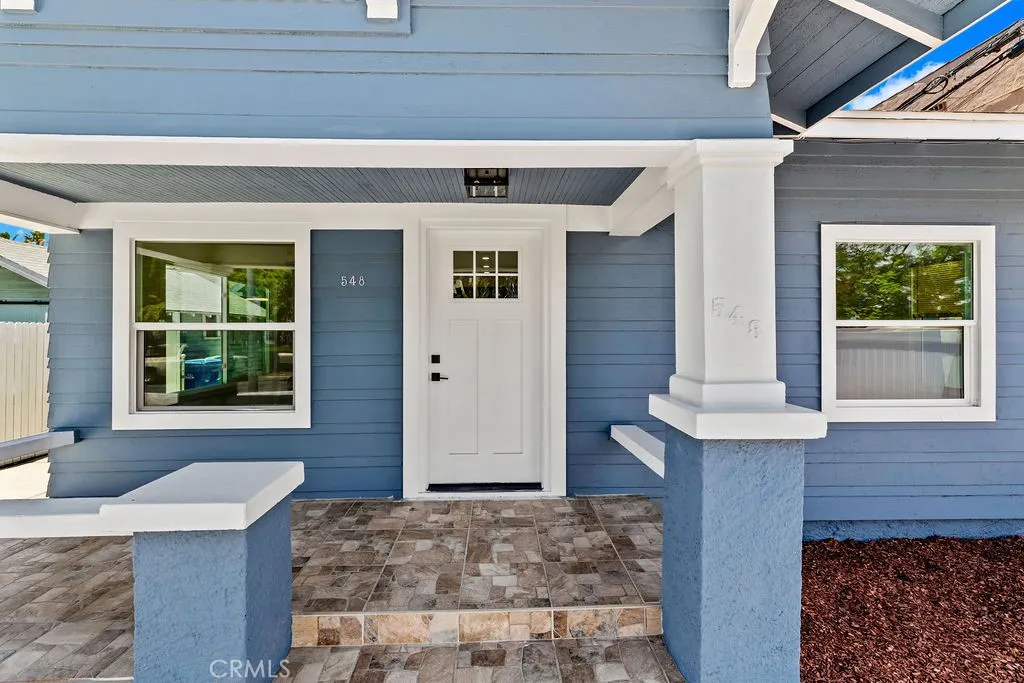 Covered front porch with Craftsman columns, tiled entry, and inviting front entrance.