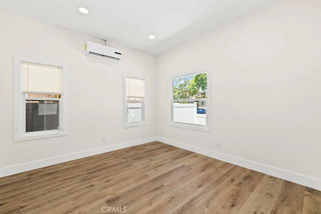 Secondary bedroom offering updated flooring, recessed lighting, and multiple windows for natural light.