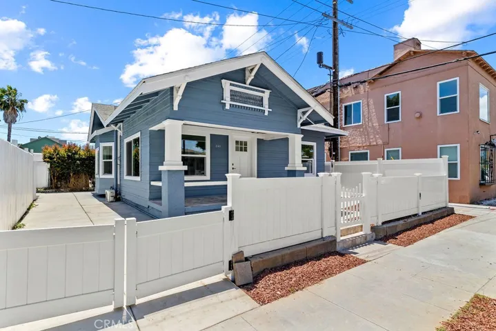 Corner exterior perspective showcasing the expansive concrete driveway and private gated parking.