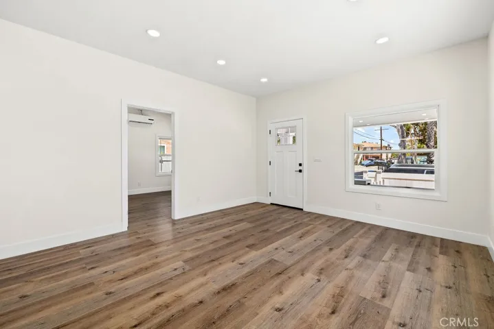 Spacious living area with updated flooring, recessed lighting, and abundant natural light.