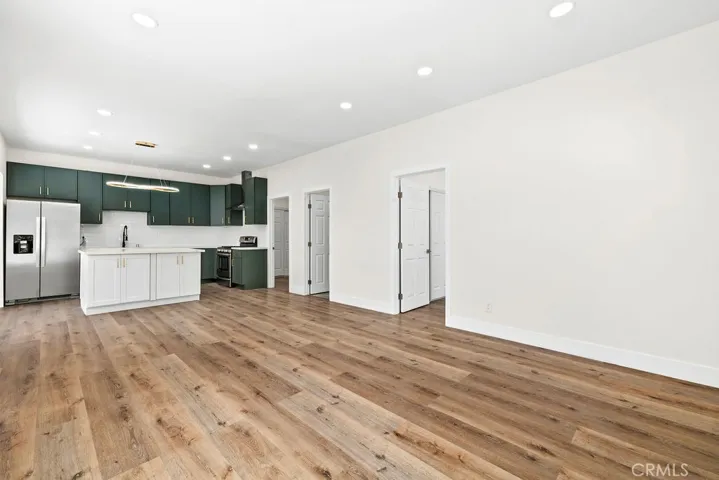 Open living area with updated flooring, recessed lighting, and seamless connection to the kitchen.