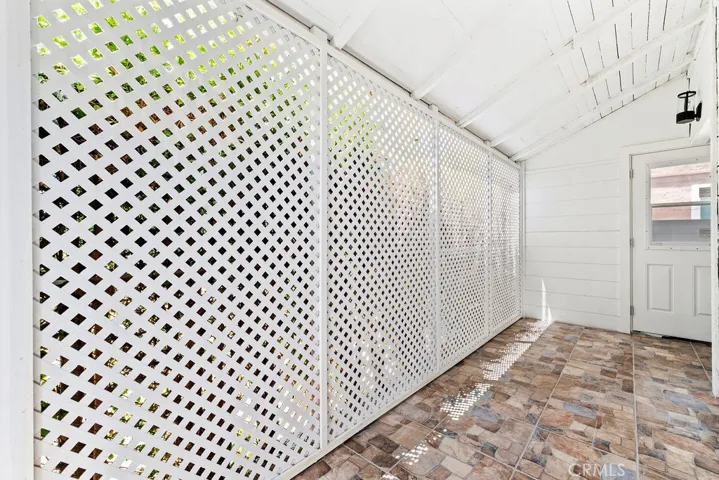 Enclosed covered patio space offering additional storage or flexible-use potential.
