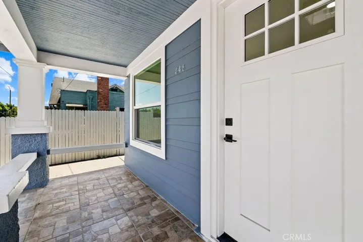 Covered front entry with tiled flooring and updated front door detail.