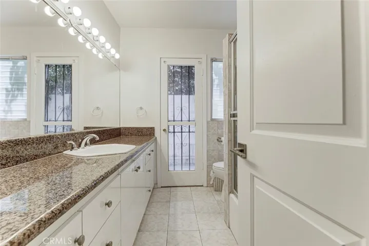 Hallway bathroom with tub & access to outside