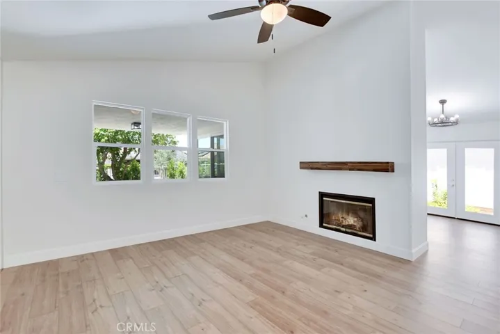 Living Room with cozy fireplace and windows overlooking back patio