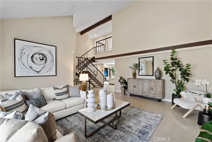 The spacious open-concept design is beautifully upgraded throughout with French-style dual pane windows and sliders, recessed lighting, marble-style tile flooring across the lower level, wide-plank wood laminate flooring upstairs, central A/C, and remodeled kitchen and baths.