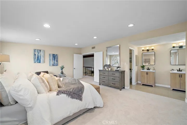 Upstairs, double doors open to the massive primary suite with recessed lighting, his-and-hers closets