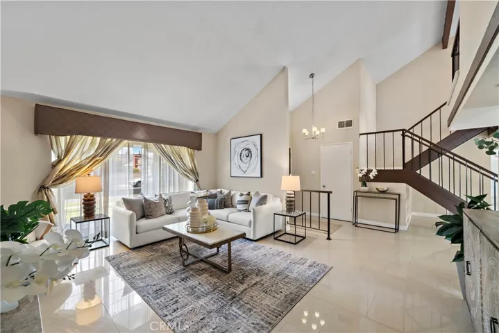 Beautiful curb appeal welcomes you with manicured landscaping, lush lawn, and a covered walkway leading to double entry doors that open to an elegant foyer and formal living room with soaring ceilings and a striking marble fireplace.