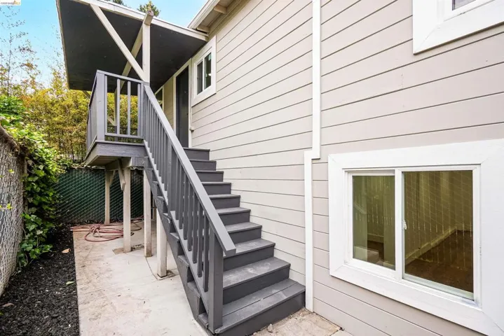 Exterior featuring horizontal siding, white trim windows, and a multi-level deck and staircase with painted wood railings