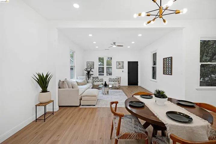 Spacious open-concept living area featuring wood-finish flooring, recessed lighting, and a modern ceiling fan