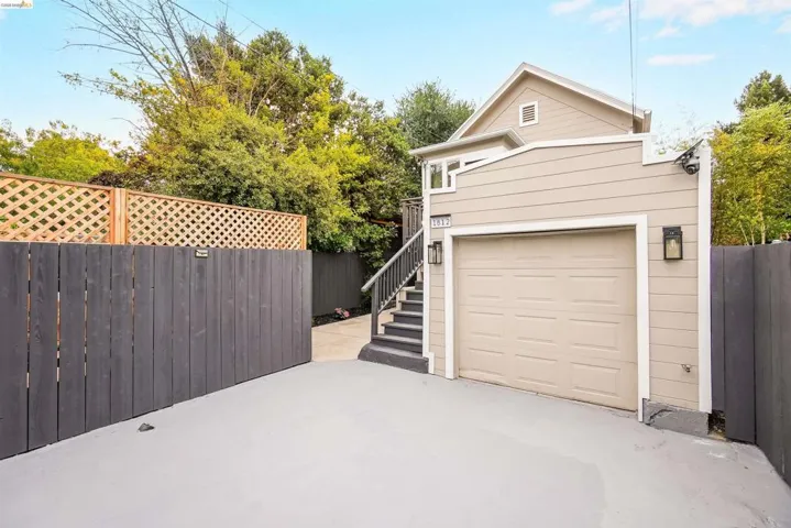 Attached garage with a panel door, complemented by a light beige exterior with horizontal siding