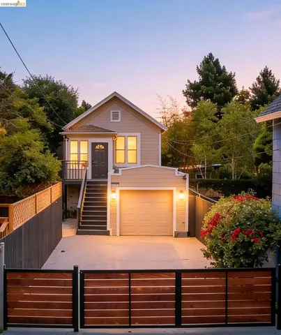 Contemporary home featuring a neutral-toned exterior, a dedicated garage, and an elevated entry with a dark gray door