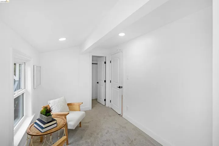 Carpeted room featuring recessed lighting, a window with white trim, and white paneled doors with matte black hardware