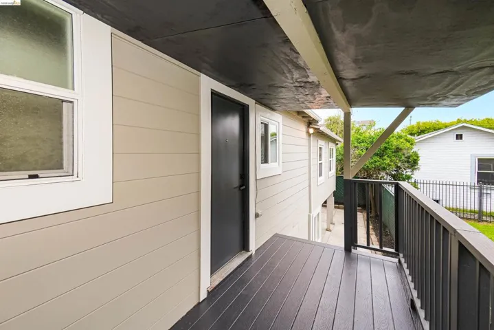 Covered porch featuring dark wood-finish decking and dark railing