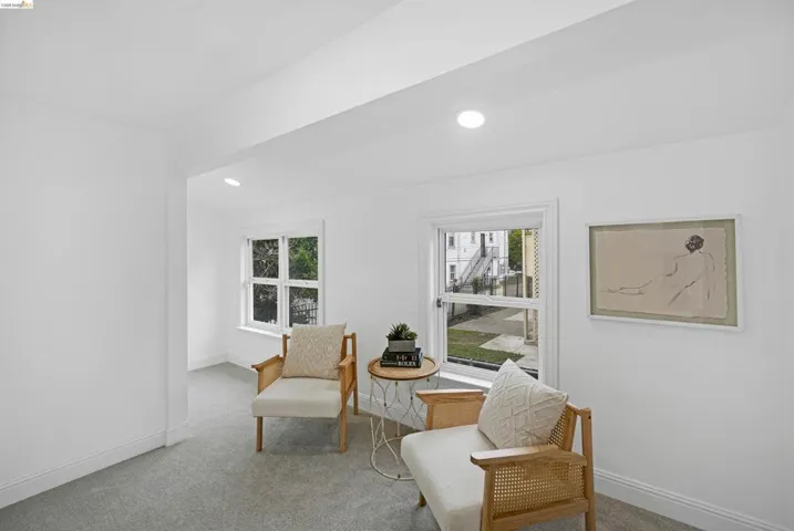 Bright room featuring neutral wall paint, recessed lighting, double-hung windows, and light gray carpeting