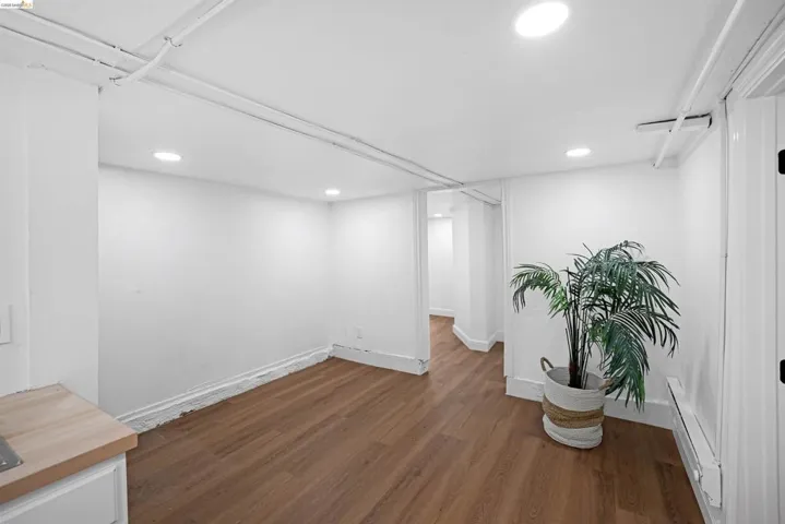 Spacious interior featuring wood-finish flooring, recessed lighting, and white walls