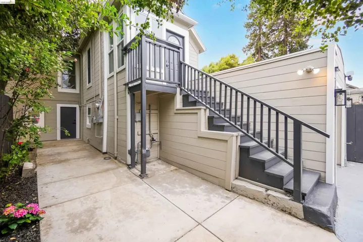 Exterior staircase with black railings leading to an upper-level entry