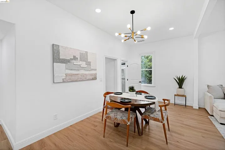 Dining area featuring light wood-finish flooring, recessed lighting, and a modern sputnik-style chandelier