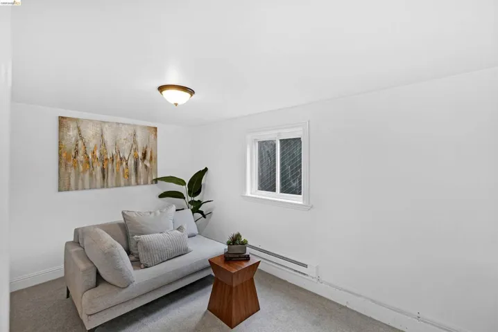 White walls with a single window, carpeted flooring, and a flush-mount ceiling light fixture