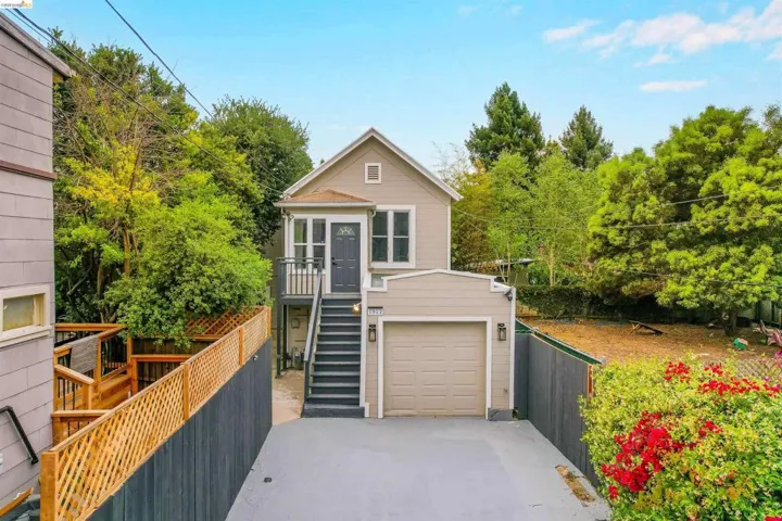 Two-story residence with an attached garage, featuring a second-level entry balcony and exterior stairs