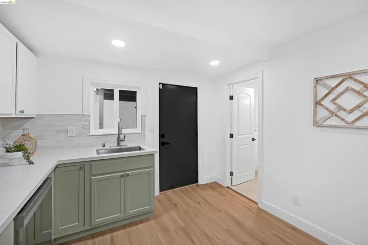 Kitchenette featuring wood-finish flooring, recessed lighting, and white walls