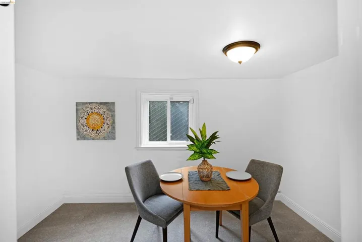 Compact dining area featuring a double-hung window, wall-to-wall carpeting, and a semi-flush mount ceiling light