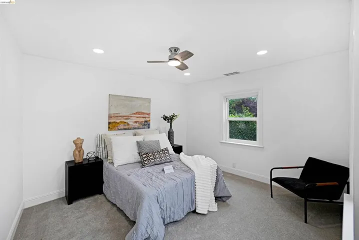 Bright room with recessed lighting and a ceiling fan