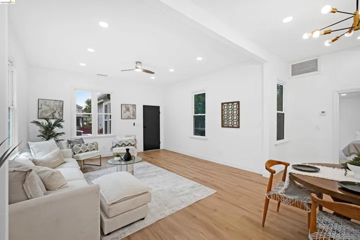 Open-concept living space featuring wood-finish flooring, recessed lighting, and a contemporary ceiling fan