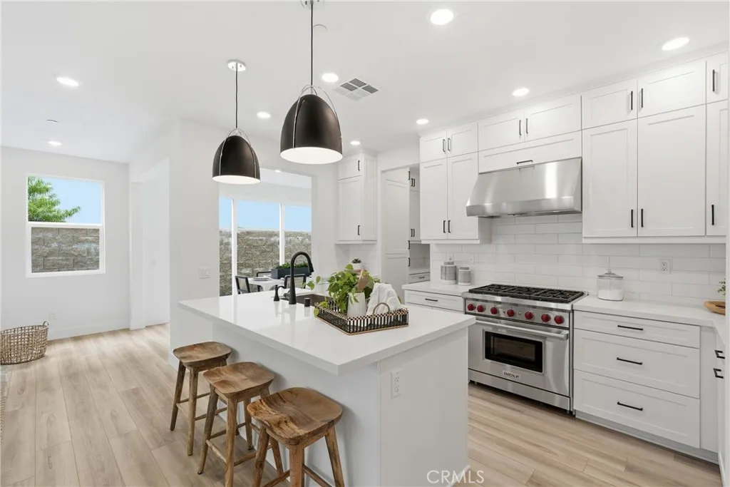 Chef-inspired kitchen featuring a premium Wolf range, quartz countertops, upgraded cabinetry, and generous workspace.