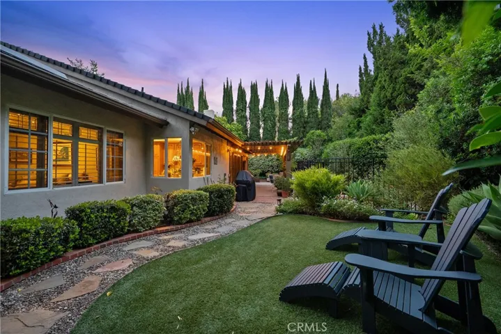 Private backyard with mature landscaping and drought tolerant turf.