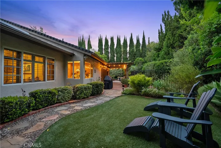 Private backyard with mature landscaping and drought tolerant turf.