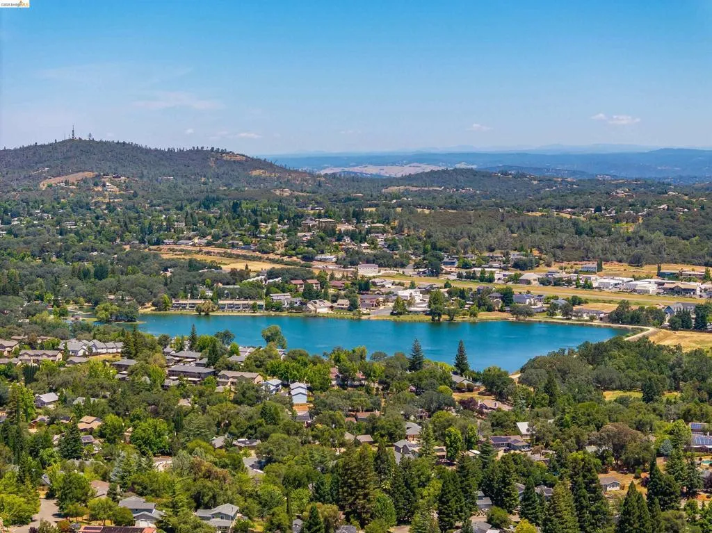 Expansive aerial perspective showcasing a residential area surrounding a tranquil lake