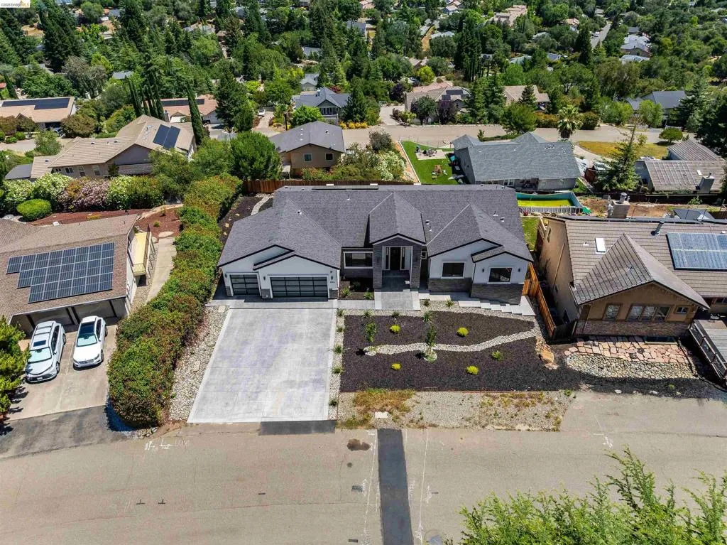Contemporary residence featuring a dark gray shingle roof and a light gray and white exterior