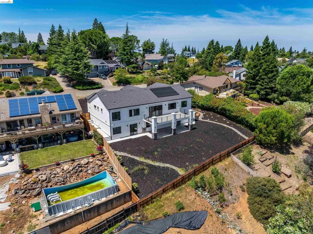 Contemporary two-story residence with a dark shingle roof and light-colored siding