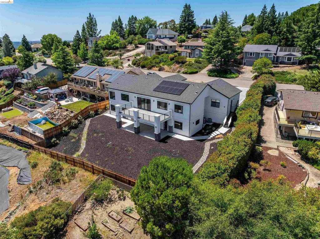 Contemporary residence featuring a dark gray shingle roof and solar panel array