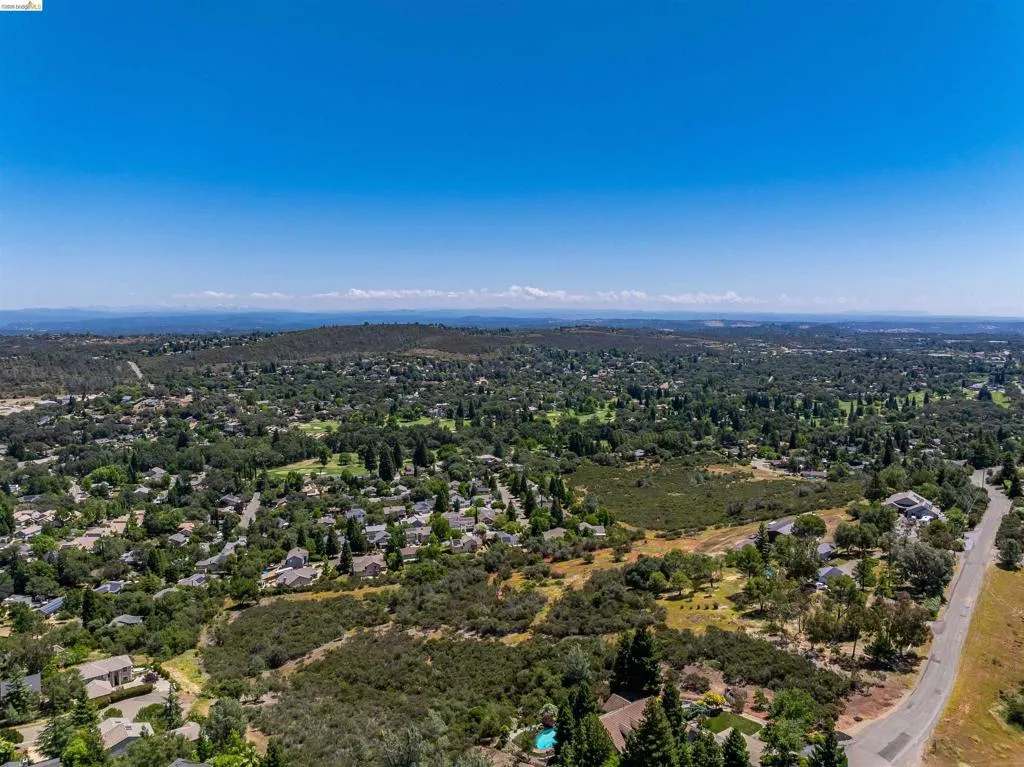 Expansive residential area featuring numerous homes nestled among abundant mature trees and natural landscapes