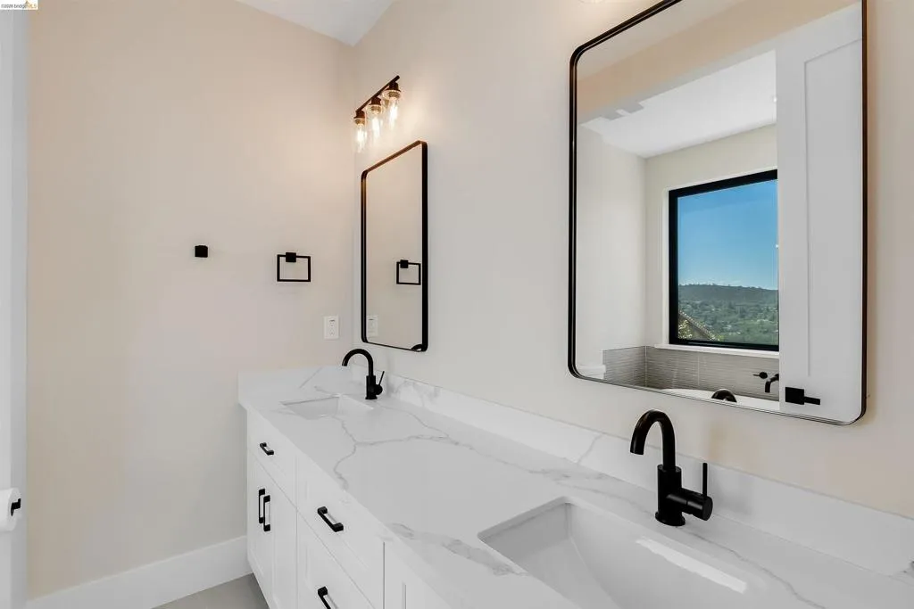 Double vanity featuring white cabinetry, integrated sinks, and a stone-finish countertop