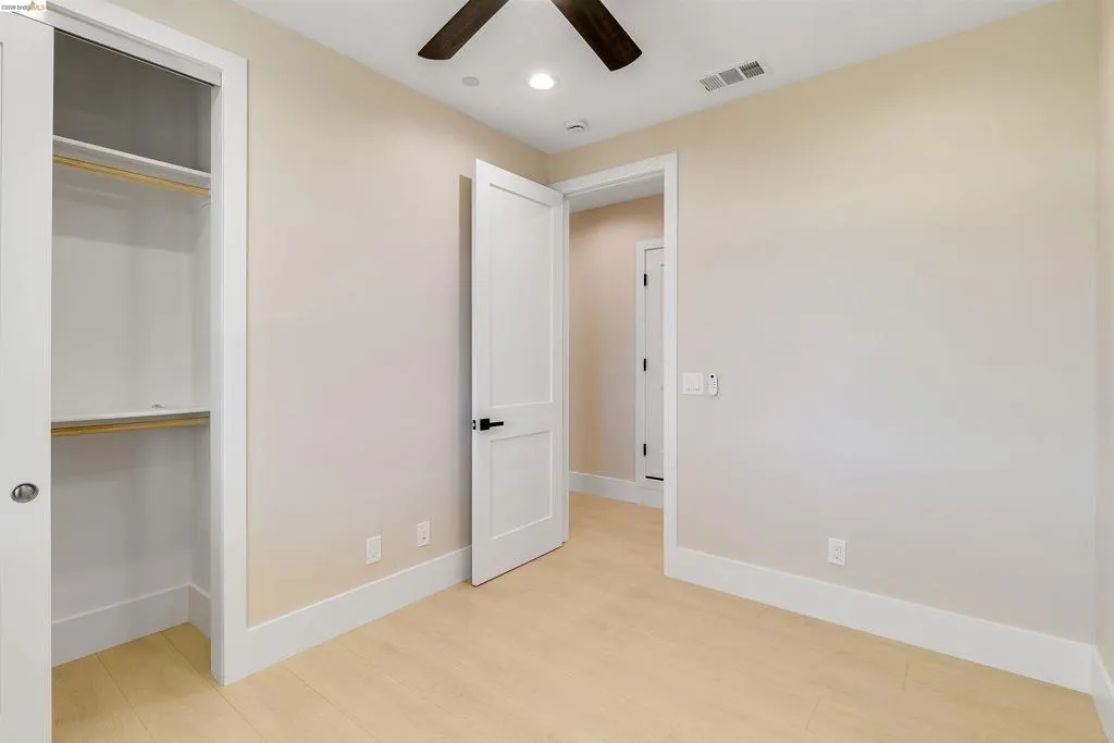 Bedroom featuring light wood-finish flooring, a ceiling fan with light, recessed lighting, and a closet with bifold doors and built-in shelving