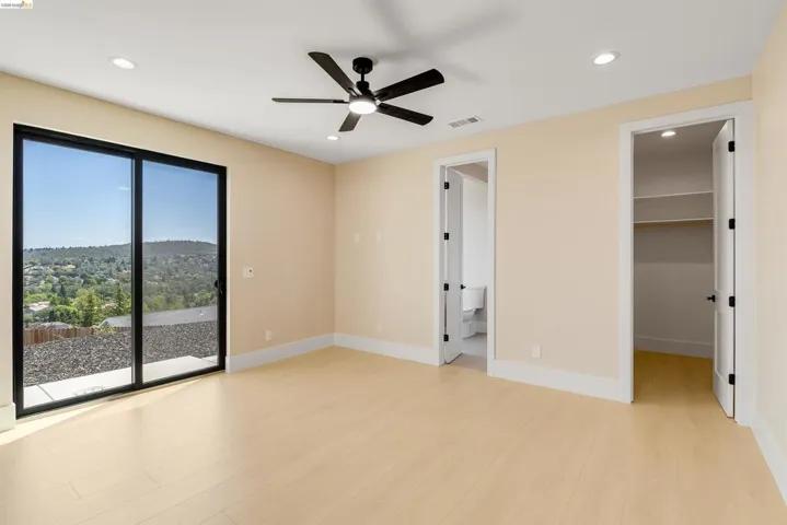 Spacious room featuring wood-finish flooring, recessed lighting, and a contemporary ceiling fan