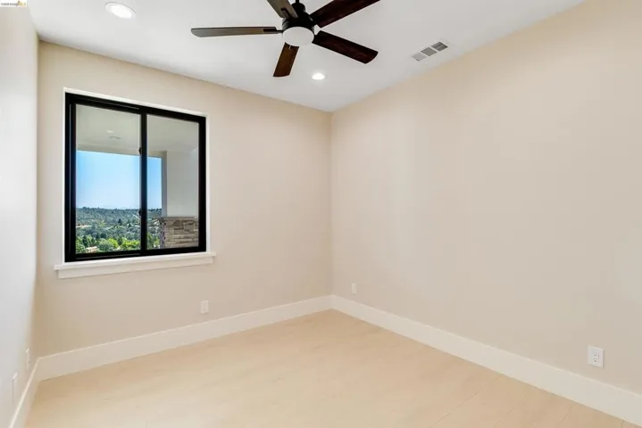 Room featuring light wood-finish flooring, a contemporary ceiling fan, recessed lighting, and a window with black trim