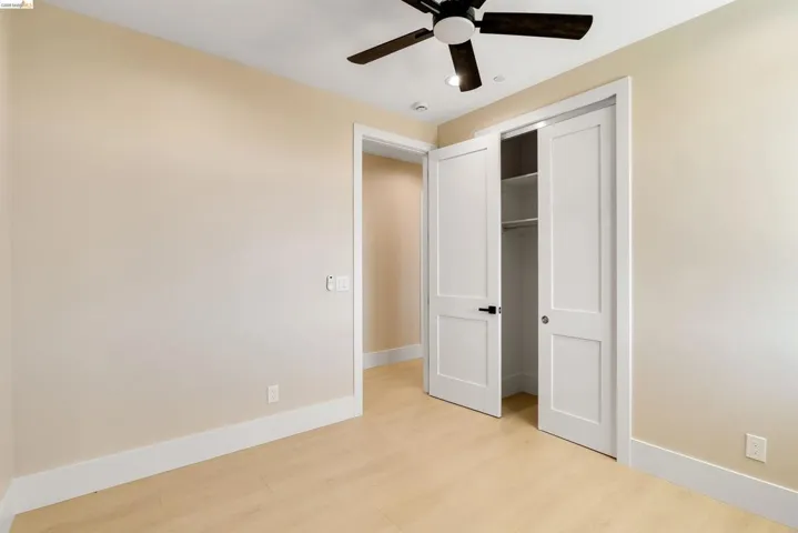 Bedroom featuring light wood-finish flooring, neutral wall tones, and bright white trim