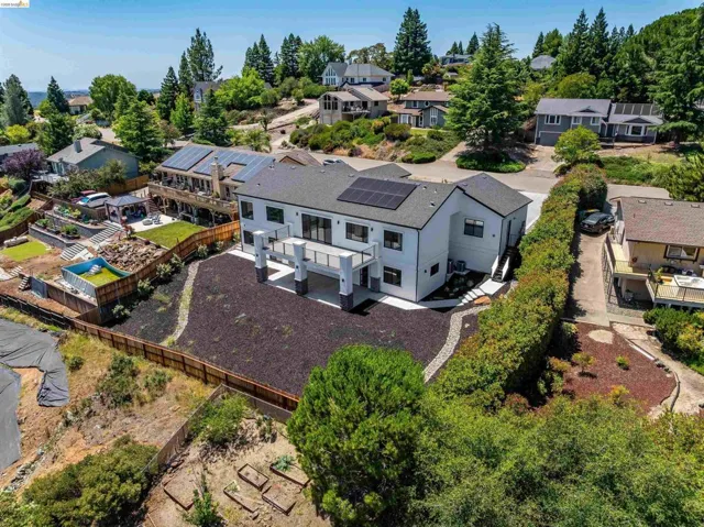 Contemporary residence featuring a dark gray shingle roof and solar panel array