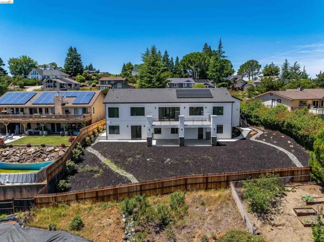 Modern white stucco exterior with a dark roof and solar panels