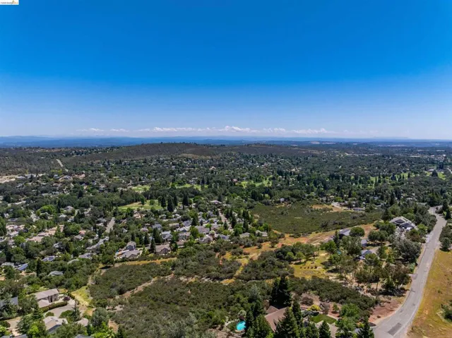 Expansive residential area featuring numerous homes nestled among abundant mature trees and natural landscapes