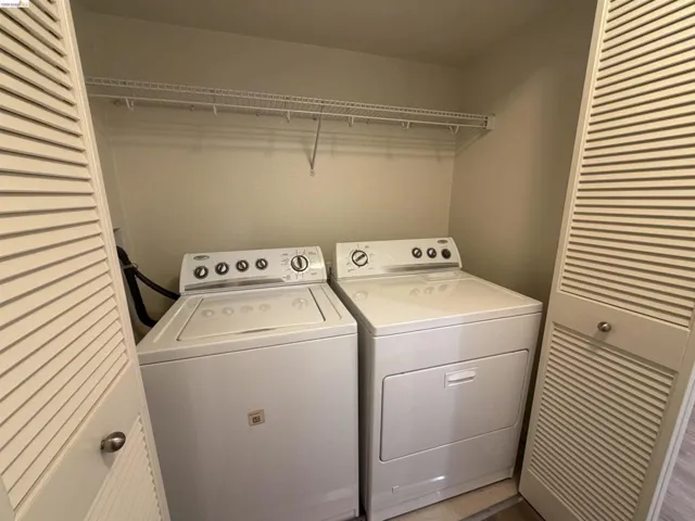 Dedicated laundry closet featuring a top-load washing machine and front-load dryer