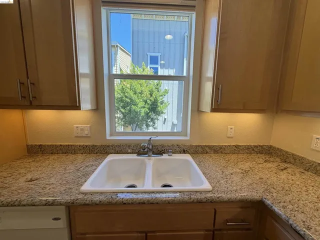 Dual-basin kitchen sink with a chrome faucet, set into a granite-finish countertop