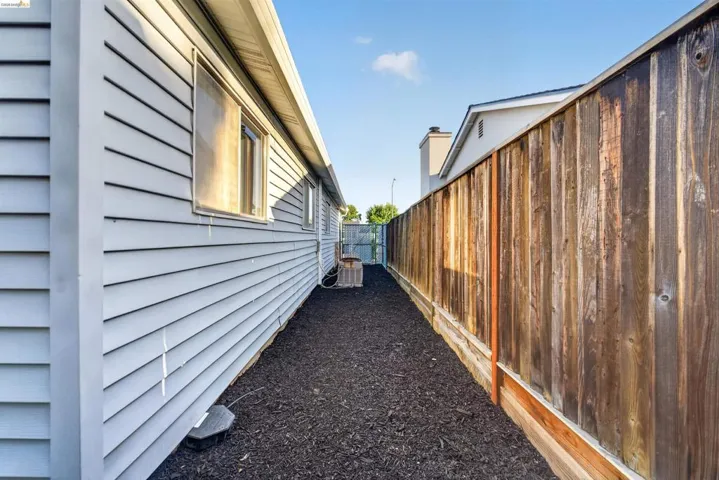 Exterior siding in a light color, featuring a window with a screen