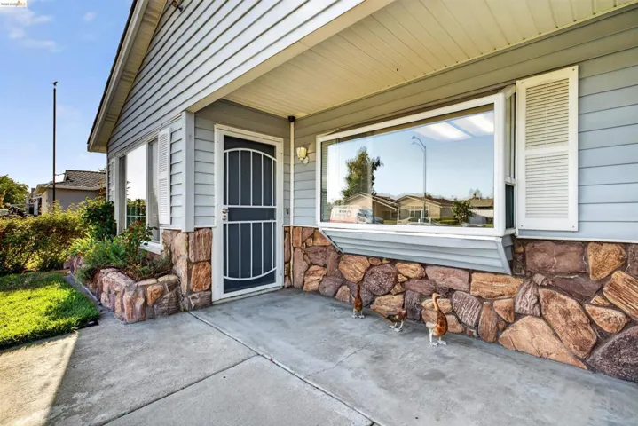 Exterior facade featuring horizontal siding, a stone veneer foundation, and a bay window